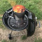 Charcoal grill with lit charcoal in chimney.