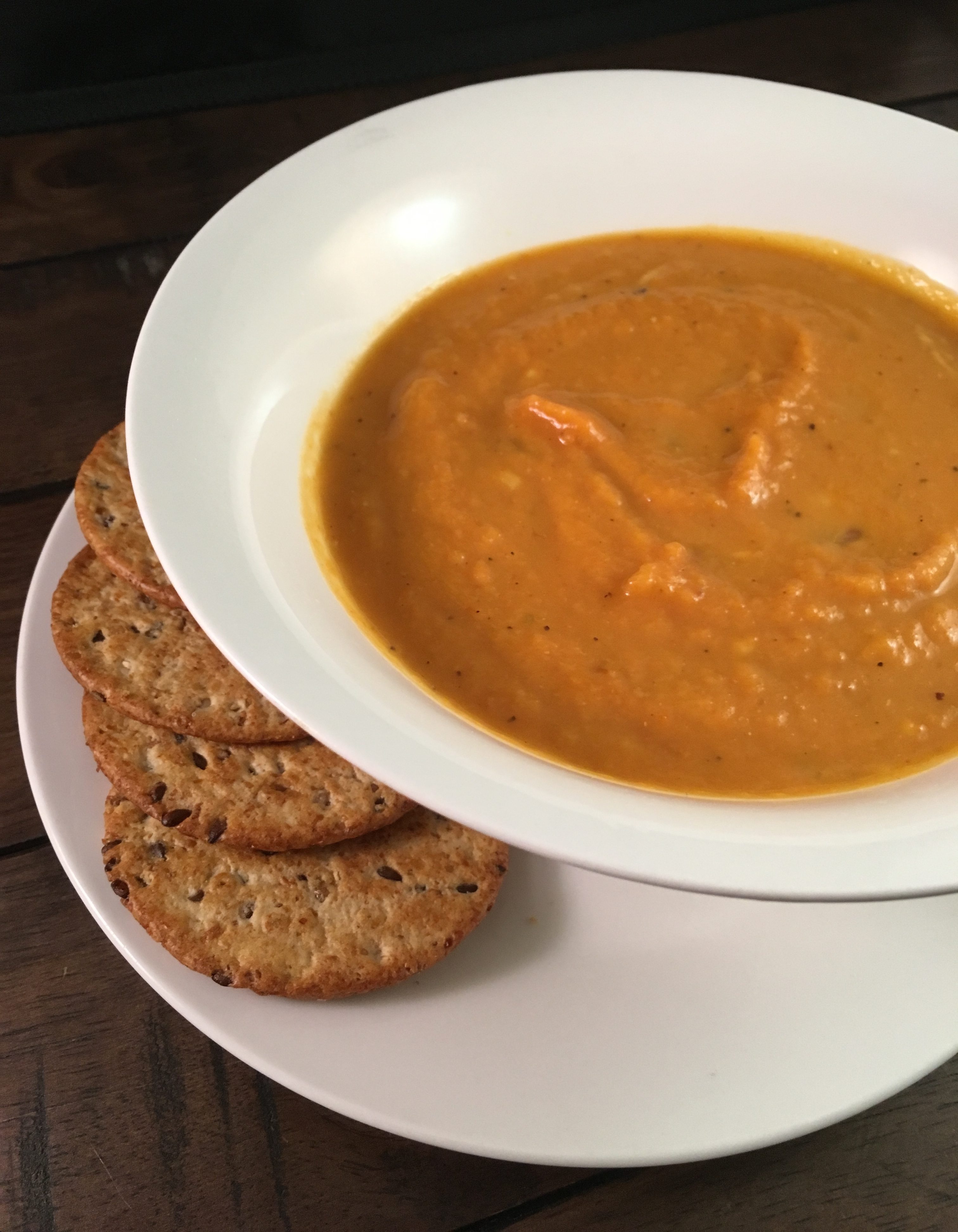 pumpkin soup in a bowl with crackers